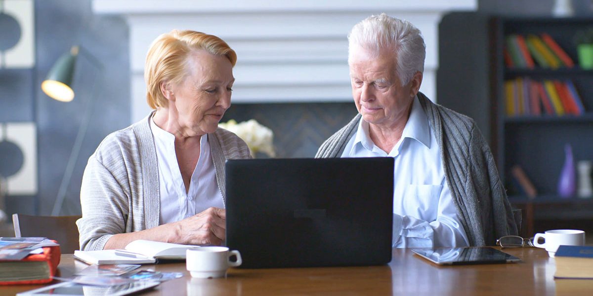 senior-couple-websurfing-on-internet-with-laptop-happy-elderly-man-and-woman-using-computer