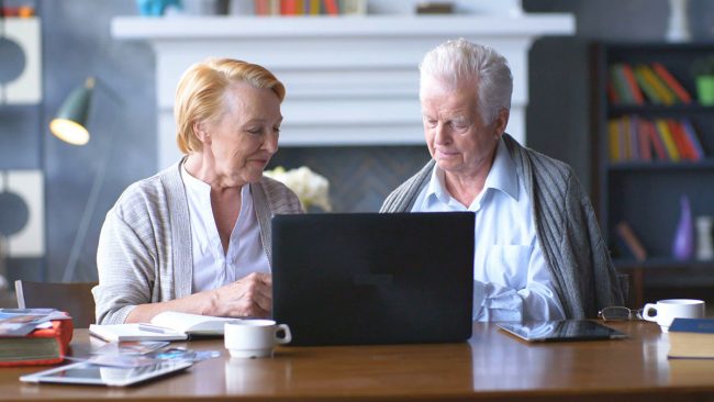 senior-couple-websurfing-on-internet-with-laptop-happy-elderly-man-and-woman-using-computer